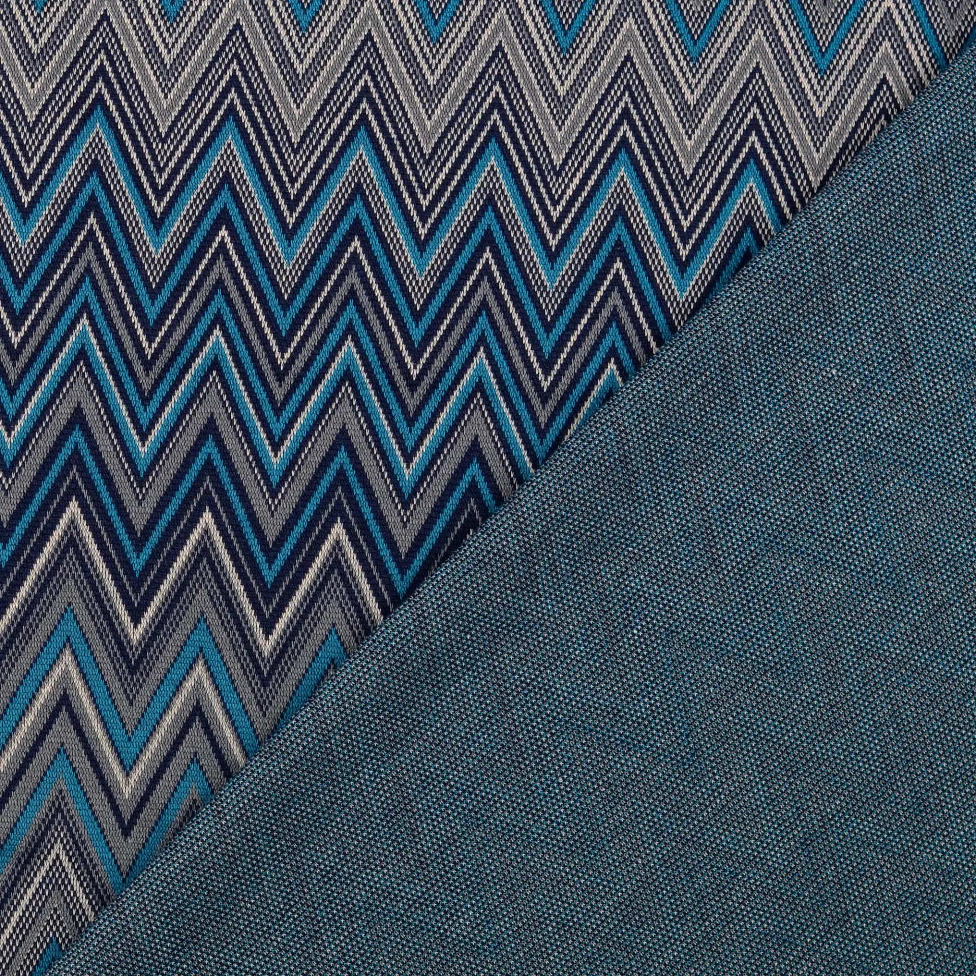 Stoffmuster mit Zickzack-Muster in verschiedenen Blau- und Grautönen, kombiniert mit einfarbigem blauen Stoff.