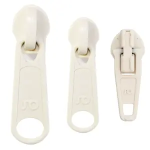 Drei Reißverschlussschieber in verschiedenen Größen, alle in hellem Farbton, mit einem einfachen und funktionalen Design.